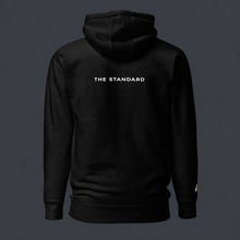 Load image into Gallery viewer, Black '4 AM NATION' hoodie with 'The Standard' logo on the back against a dark background